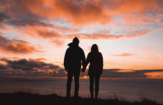 Two people hand-in-hand on beach